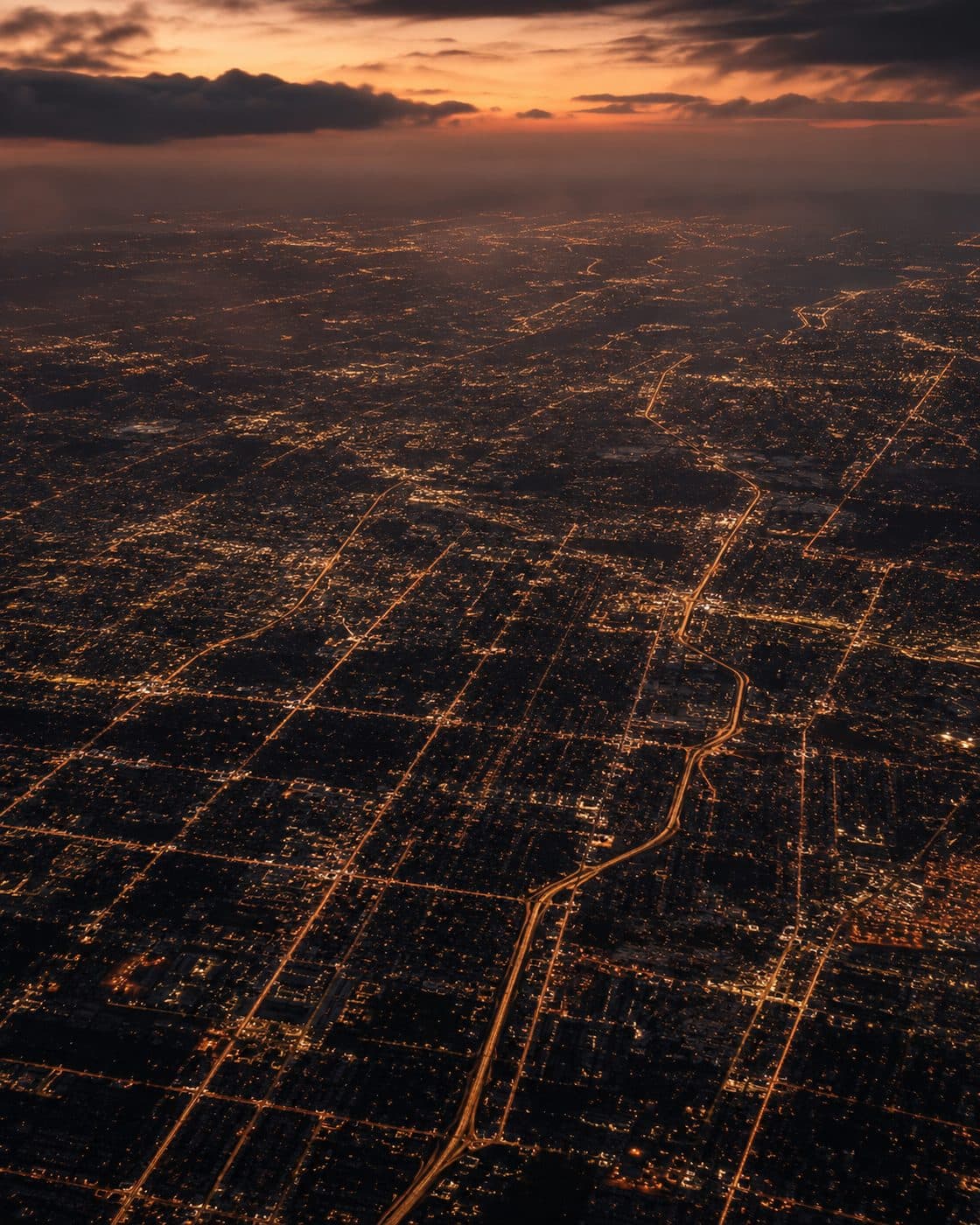 Aerial view of a city street grid glowing at dusk